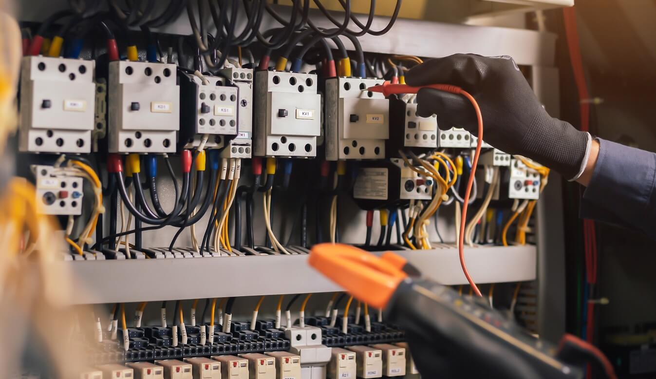 électricien qui contrôle un boitier électrique