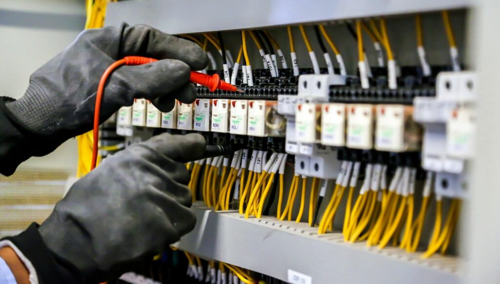 électricien qui contrôle le disjoncteur électrique