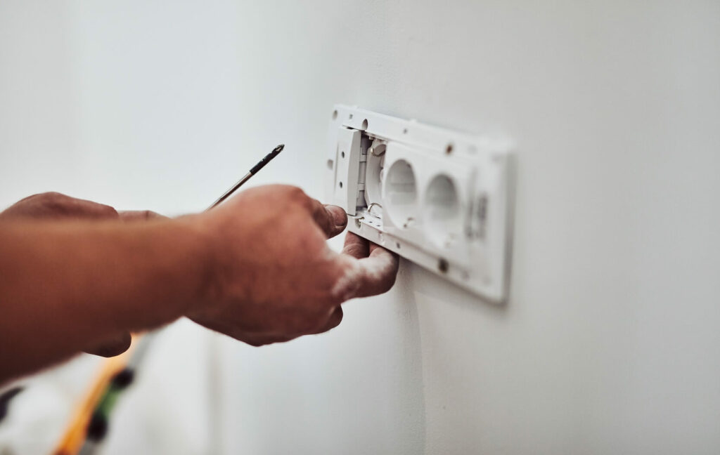 électricien qui installe une prise
