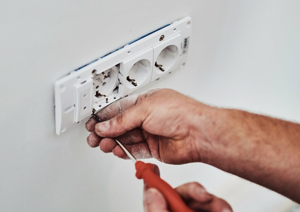 électricien qui installe des prises murales